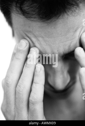 Mann berühren Stirn mit Fingern, Nahaufnahme, schwarz und weiß. Stockfoto