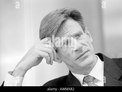 Geschäftsmann, schiefen Kopf einerseits und gerunzelter Stirn, close-up, schwarz und weiß. Stockfoto