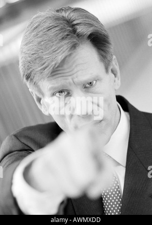 Geschäftsmann in die Kamera, Hand verschwommen im Vordergrund, Schwarzweiss, Portrait zeigt. Stockfoto