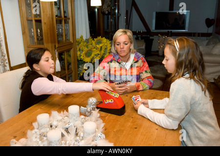 Mutter Spielkarten mit zwei zehn-jährige Kinder Stockfoto