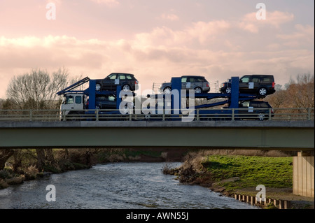 Ein Autotransporter mit Range Rover eine Brücke über einen Fluss überqueren Stockfoto