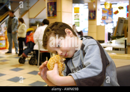 Kleiner Junge Essen Mcdonald's Big Mac, England UK Stockfoto