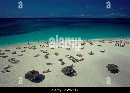Touristen Schwimmer schwimmen Sonnenanbeter Sonnenbaden am Strand auf Paradise Island auf den Bahamas, West Indies Stockfoto