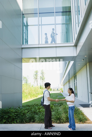 Zwei Studenten auf dem Campus das Händeschütteln Stockfoto