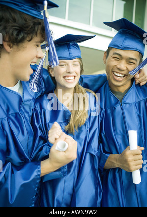 Absolventinnen und Absolventen hält Diplome und lachen Stockfoto