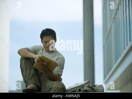 Junger Mann im Freien auf dem Campus studieren Stockfoto