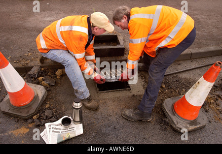 GLOUCESTER CITY COUNCIL ARBEITNEHMER ERSETZEN EINE ABFLUSS ABDECKUNG RE HOHEN PREIS SCHMIEDEARBEITEN FÜR SCHROTT MÄRZ 2004 Stockfoto