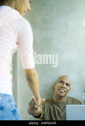 Junge Frau, die Hand auf die Menschen zugehen Stockfoto