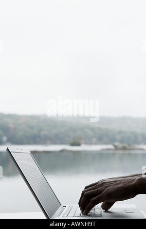 Ein Personen-Hände auf einem Laptop eingeben Stockfoto