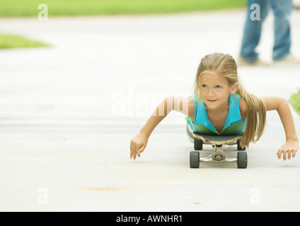 Mädchen liegend auf skateboard Stockfoto