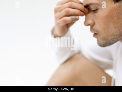 Mann, der Nasenrücken mit Fingern, Seitenansicht, Nahaufnahme Stockfoto