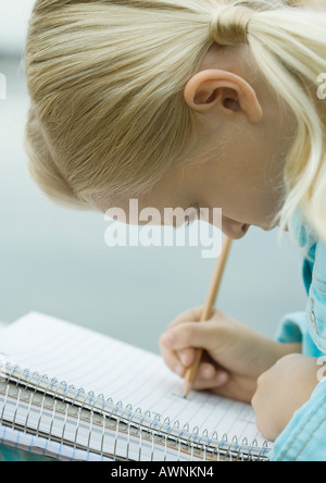 Mädchen schreiben in notebook Stockfoto