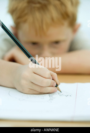 Junge, die Zeichnung in notebook Stockfoto