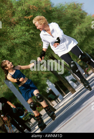 Reife Frau und Mädchen Hand in Hand, Inline-Skaten Stockfoto