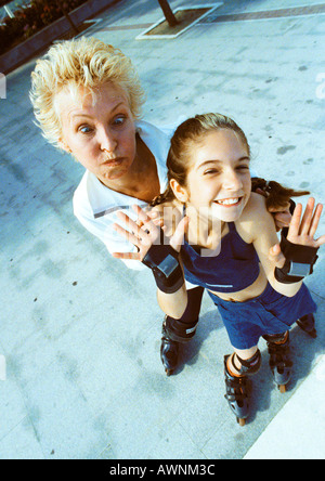 Reife Frau und junges Mädchen auf Inline - Skates, Grimassen in die Kamera, erhöhte Ansicht Stockfoto