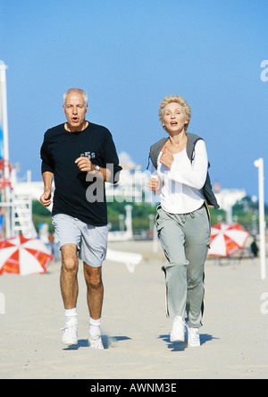 Älteres paar jogging am Strand, Vorderansicht, in voller Länge Stockfoto