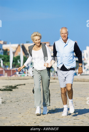 Älteres Paar Hand in Hand spazieren am Strand, Vorderansicht, in voller Länge Stockfoto