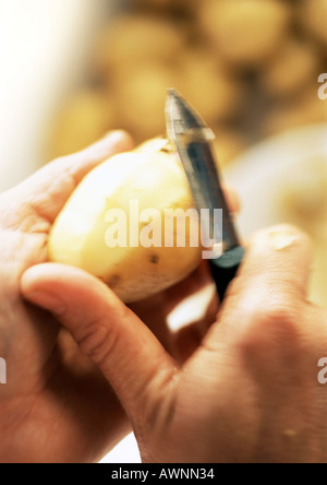 Nahaufnahme der Hände eine Kartoffel schälen Stockfoto