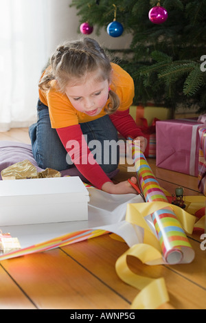 Ein Mädchen schneiden Geschenkpapier Stockfoto