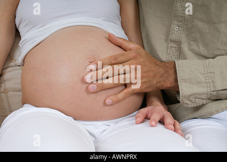 Ein Mann, einen schwangere Womans Bauch zu berühren Stockfoto
