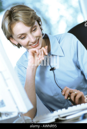 Geschäftsfrau tragen Kopfhörer am Schreibtisch Stockfoto