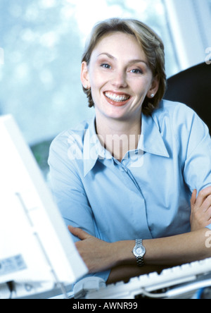 Geschäftsfrau am Schreibtisch, lächelnd in die Kamera, Porträt Stockfoto