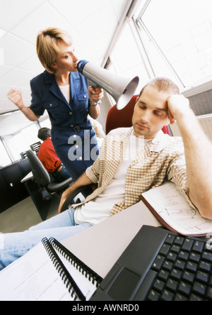 Geschäftsfrau mit Megaphon um zu wecken schlafende Kollege Stockfoto