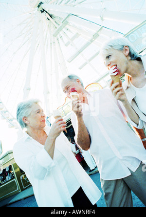 Pensionierte Freunde essen Eis im Vergnügungspark Stockfoto