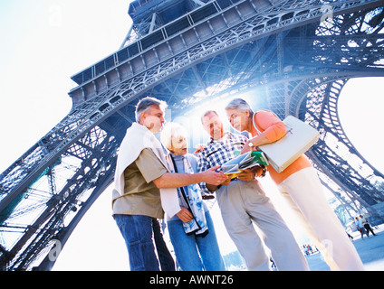 Frankreich, Paris, Reife Touristengruppe Prüfung eine Landkarte vor Eiffelturm, niedrigen Winkel Ansicht Stockfoto