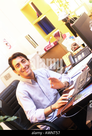 Menschen arbeiten am Schreibtisch im Büro, in die Kamera Lächeln Stockfoto