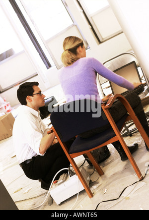 Mann und Frau arbeiten auf Laptop-Computer auf Stuhl Stockfoto