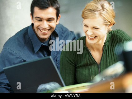 Geschäftsmann und Frau mit Laptop-Computer, Lächeln Stockfoto
