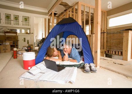 Paar in seinem unvollendeten Wohnzimmer camping Stockfoto