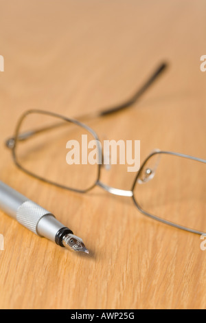 Brille und einem Füllfederhalter auf einem Schreibtisch Stockfoto