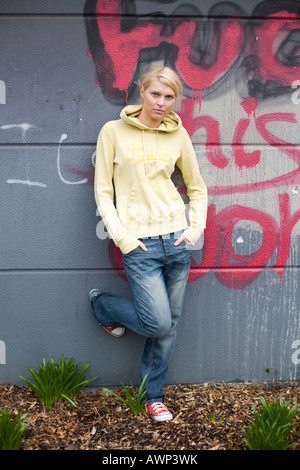 Porträt einer jungen blonden Frau stand vor einer Wand Graffiti bedeckt Stockfoto