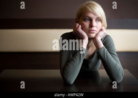 Blonde Frau, die traurig sitzt an einem Tisch in einer bar Stockfoto