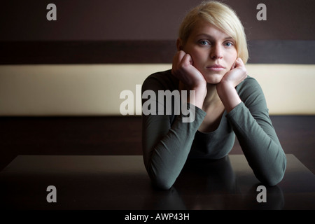 Blonde Frau, die traurig sitzt an einem Tisch in einer bar Stockfoto