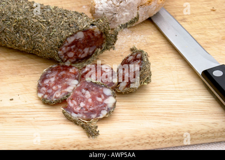 Sauccisson an Bord mit Brotmesser Sauccisson ummantelt Herbes de Provence und geschnitten, um Fleisch zu offenbaren Stockfoto