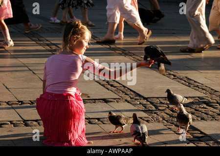 Junge Mädchen, die Tauben füttern, in der Altstadt von Danzig, Polen, Europa Stockfoto