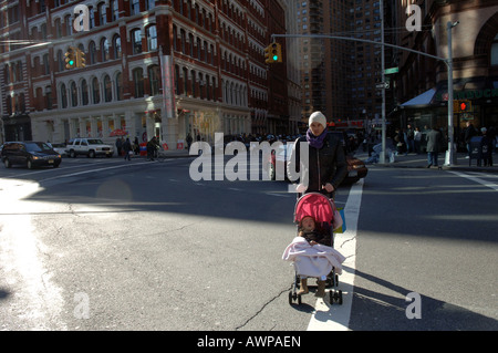 Ein Vater und sein Kind in einem Kinderwagen cross Astor Place im East Village in New York City Stockfoto