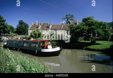 Wasserstraße. Bathampton Dorf. Häuser. Reihe von Hütten. Leinpfad. Mann sitzt im Bug des schmalen Boot auf dem Wasser. Stockfoto