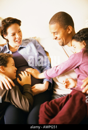 Paar mit Kindern, lächelnd sitzt Stockfoto