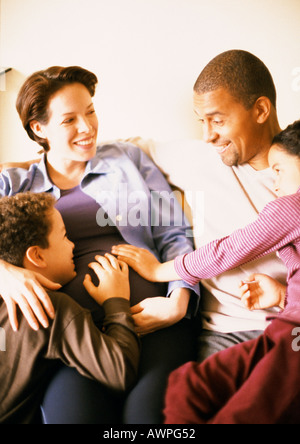 Paar mit Kindern, lächelnd sitzt Stockfoto