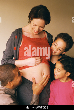 Mann und Kinder Blick auf schwangere Frau ausgesetzt Magen Stockfoto
