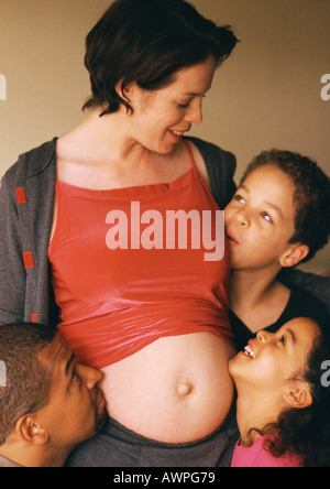 Mann und Kinder um exponierten schwangeren Frau Bauch Stockfoto