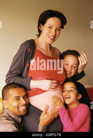 Mann und Kinder um exponierten schwangeren Frau Bauch Stockfoto