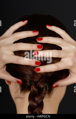 Junge Frau mit den Händen auf den Kopf Stockfoto