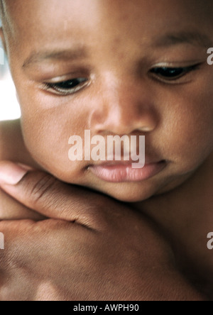Baby mit Erwachsenen Hand auf der Brust, Nahaufnahme Stockfoto