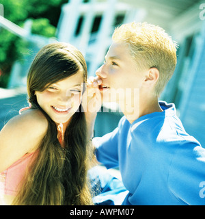 Jungen flüstern Mädchen nebeneinander stehen Stockfoto