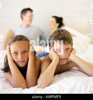 Kinder liegen im Bett der Eltern, Blick in die Kamera Stockfoto